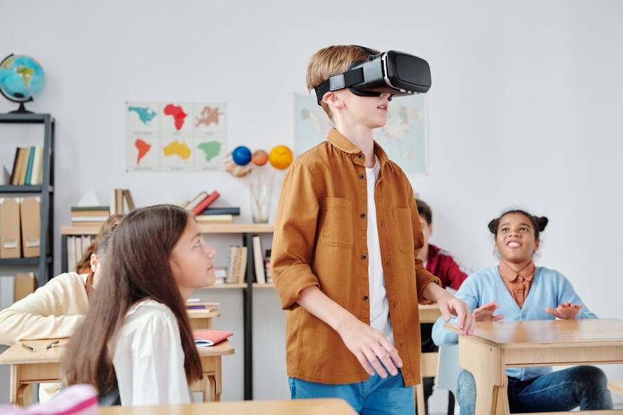 Klasse beobachtet gespannt einen Mitsch&uuml;ler mit VR-Headset.